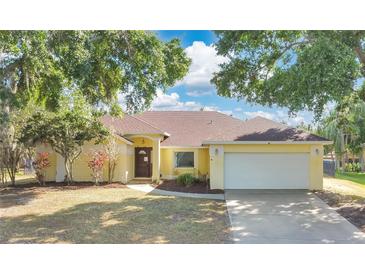 Inviting one-story home with a two-car garage, mature trees, and a well-manicured front yard at 1512 Adriatic Dr, Ocoee, FL 34761