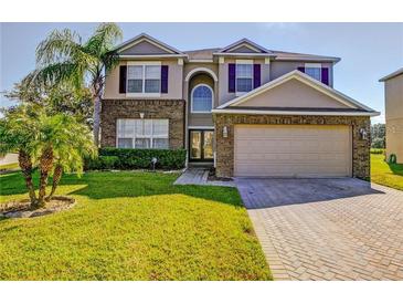 Charming two-story home with brick accents, well-manicured lawn, and attached two-car garage at 173 Donner Dr, Winter Garden, FL 34787