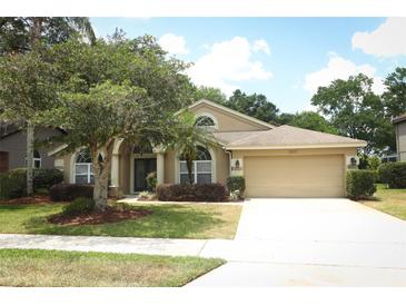 Charming single-story home with mature landscaping, manicured lawn, and a two-car garage at 1937 Crystal Downs Ct, Oviedo, FL 32765