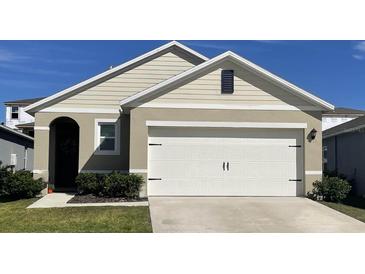 Charming single-Gathering home with a two-car garage, neat landscaping, and neutral color scheme at 194 Amberwood Way, Umatilla, FL 32784