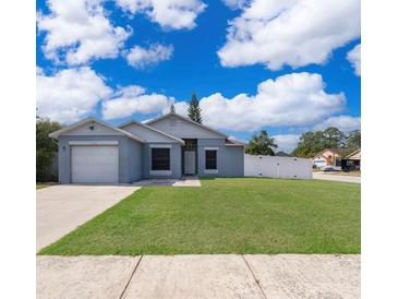 Charming single-story home featuring a well-maintained lawn and a white picket fence at 2164 Rj Cir, Kissimmee, FL 34744