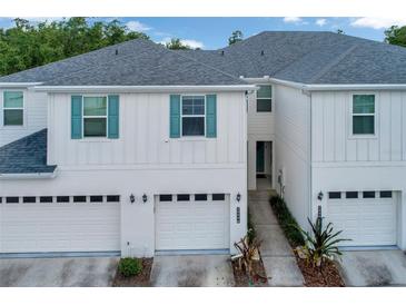 Attractive townhouse with white siding, teal shutters and a one car garage at 2956 Oak Park Way # B, Orlando, FL 32822