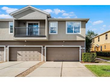 Charming townhome featuring a two-car garage, balcony, and neutral exterior paint at 3917 Pemberly Pines Cir, St Cloud, FL 34769