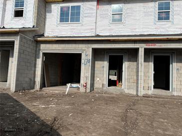 Unfinished townhome exterior featuring gray block construction and window openings at 4283 Campsite Loop, Orlando, FL 32824