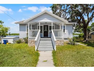 Charming home featuring a welcoming front porch, stone accents and manicured lawn at 730 S Main Ave, Groveland, FL 34736