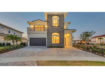 Beautiful two-story home featuring stone accents, manicured landscaping, and a spacious driveway at 7905 Jacks Club Dr, Kissimmee, FL 34747