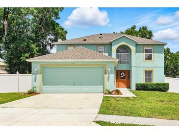 Inviting two-story home with a two-car garage, well-manicured lawn, and beautiful landscaping at 905 Cascade Falls Ln, Deland, FL 32720
