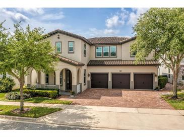 Stunning two-story home featuring a three-car garage and a brick paved driveway at 9574 Meadow Hunt Way, Winter Garden, FL 34787