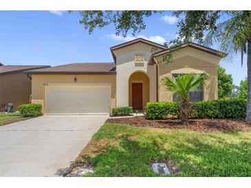 Charming single-Gathering home with a well-maintained lawn, mature landscaping, and attached two-car garage at 1023 Hermosa Way, Kissimmee, FL 34744