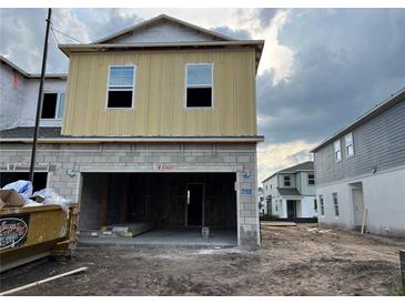 Unfinished two story home with cinder block garage and siding on the second floor at 14930 Harvest St, Orlando, FL 32824