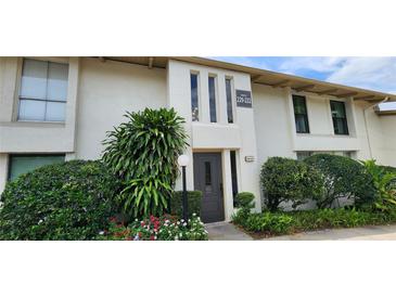 Condo exterior with lush landscaping, mature trees and black trimmed windows at 200 Maitland Ave # 232, Altamonte Springs, FL 32701