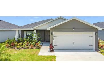 Charming single-story home featuring a two-car garage and beautifully landscaped front yard at 2005 Noble Dr, Davenport, FL 33837