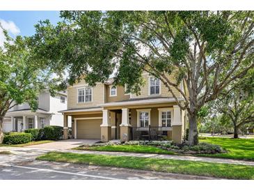Street view featuring a two-story home with a large front porch and attached garage at 2116 Truffle Ln, Casselberry, FL 32707