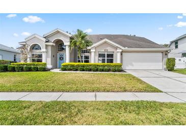 Charming single-Gathering home featuring a well-manicured lawn and a light blue front door with decorative wreath at 633 Lakehaven Cir, Orlando, FL 32828