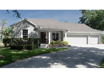 Charming home with a well-manicured lawn, flower beds, covered porch, and a two-car garage at 6350 Sedona Leaf Ct, Windermere, FL 34786