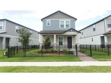 Charming two-story home boasts a well-maintained lawn and sleek black fence, creating a welcoming curb appeal at 12272 Bracco St, Winter Garden, FL 34787