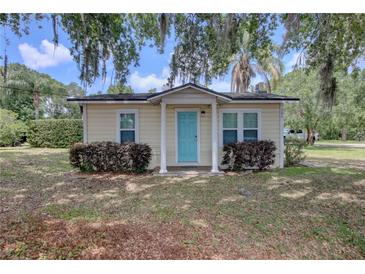 Charming single-story home featuring a vibrant blue door and well-maintained landscaping at 200 W 27Th St, Sanford, FL 32773