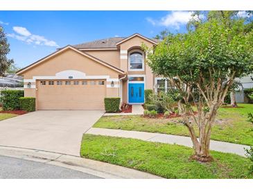 Charming two-story home featuring a well-maintained lawn, a two-car garage, and a vibrant blue front door at 3468 Woodley Park Pl, Oviedo, FL 32765