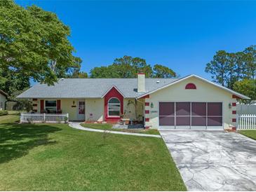 Charming single-story home with a well-manicured lawn and two-car garage at 5583 Miles Dr, Port Orange, FL 32127