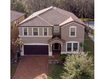 Charming two-story home with a tile roof, manicured lawn, and an attached two-car garage at 8924 Bengal Ct, Kissimmee, FL 34747