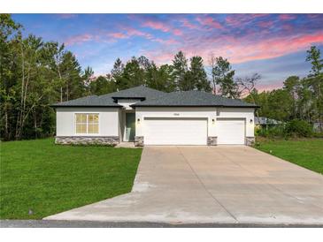 Beautiful single-story home with a well-manicured lawn and a spacious two-car garage at 13068 Sw 36Th Ct, Ocala, FL 34473