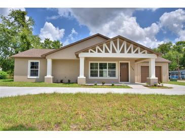 Charming single-story home featuring a decorative gable, covered front porch, and a well-manicured lawn at 1390 E Wabash St, Bartow, FL 33830