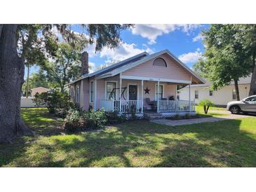 Charming cottage-style home featuring a cozy front porch with a swing and well-manicured landscaping at 2305 S Magnolia Ave, Sanford, FL 32771