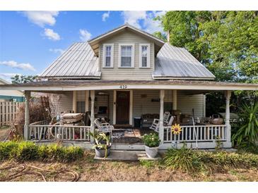 Charming two-story home with a metal roof and a covered porch, surrounded by landscaping at 419 Palm Ave, Eustis, FL 32726