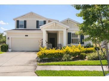 Charming two-story home featuring well-manicured landscaping, a front porch, and an attached garage at 4459 Bluff Oak Loop, Kissimmee, FL 34746