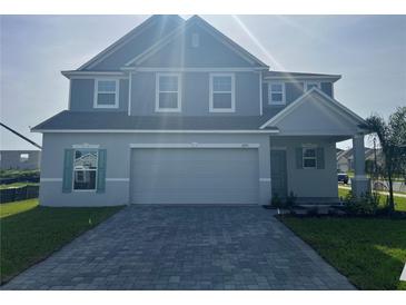 Beautiful two-story home featuring a well-manicured lawn and a paved driveway at 4891 Lyric Dr, Mascotte, FL 34753