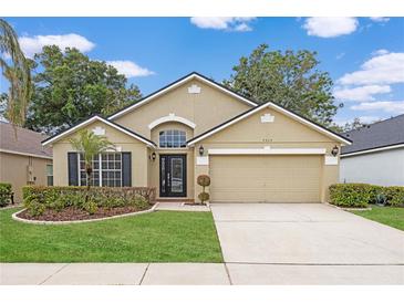 Charming single-story home with manicured lawn, two-car garage, and inviting front entrance at 9545 Southern Garden Cir, Altamonte Springs, FL 32714