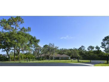 Charming single story home featuring mature trees and a lush lawn at 15305 Shady Ln, Tavares, FL 32778