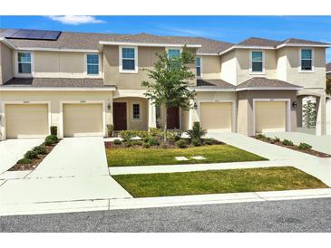 Charming townhome exterior boasts neutral colors, well-manicured lawn, and individual driveways at 2029 Crystal Bell St, Orlando, FL 32824