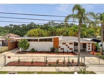 Unique mid-century home featuring a concrete fence, stucco walls, and orange trim at 2303 Bonneville Dr, Orlando, FL 32826