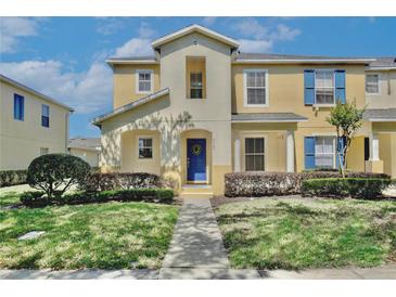 Charming two-story townhome featuring a blue front door, well-maintained landscaping, and a welcoming entrance at 2460 Formax Dr, Orlando, FL 32828