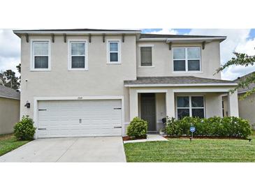Charming two-story home features a two car garage, well-manicured lawn and lush shrubbery at 2524 Harmonia Hammock Rd, Harmony, FL 34773