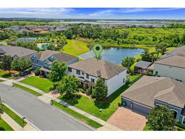 Beautiful aerial view of lakeside home with manicured lawn, lush trees, and stunning neighborhood amenities at 408 Egret Place Dr, Winter Garden, FL 34787