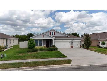 Beautiful single-Gathering home with well-maintained landscaping, three-car garage, and covered front porch at 449 Halter Dr, Apopka, FL 32712
