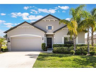 Beautiful single-story home featuring a well-manicured lawn, elegant landscaping, and a two-car garage at 112 Red Maple Burl Cir, Debary, FL 32713