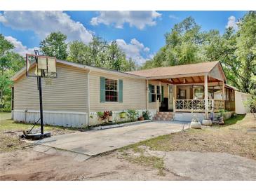 Single story home with a cozy porch and a basketball hoop in the driveway at 18240 Lynbrook Rd, Orlando, FL 32820