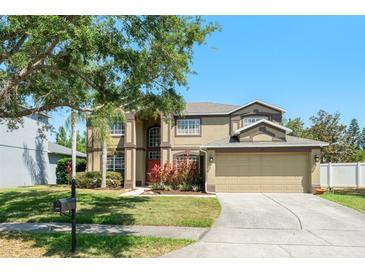 Well-maintained two-story home featuring a two-car garage, mature trees, and landscaped front yard at 2644 Slagrove Ct, Winter Garden, FL 34787