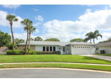 Charming single-story home featuring a well-manicured lawn, palm trees, and a two-car garage at 3317 Dormer Ct, Winter Park, FL 32792