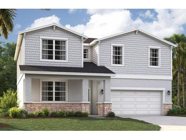 Charming two-story home with gray siding, stone accents, and a well-manicured lawn at 3565 Dahlia Dr, Lake Hamilton, FL 33851