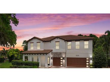 Stunning two-story home with a tile roof, stone accents, and a meticulously manicured front yard at 4509 Patricia Ann Ct, Orlando, FL 32839