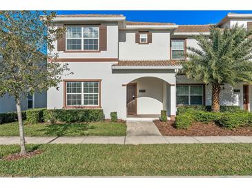 Charming two-story townhouse featuring a well-manicured lawn and a welcoming arched entryway at 4918 Windermere Ave, Kissimmee, FL 34746