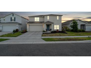 A beautiful two-story home with an attached garage, neat landscaping, and a welcoming entrance at 555 Meadow Bend Dr, Davenport, FL 33837