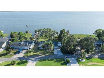 Waterfront property with a private dock and lush landscaping situated on a serene lake at 7046 Treasure Island Rd, Leesburg, FL 34788