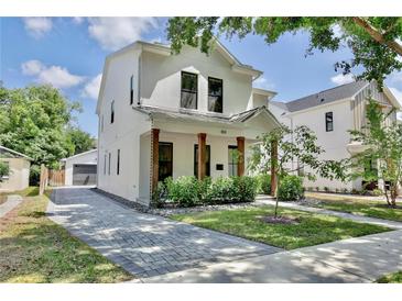 Stunning two-story home featuring a brick driveway, wooden beams and lush landscaping at 833 Dartmouth St, Orlando, FL 32804