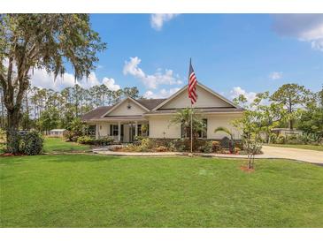 Charming single-story home with a large front yard and an American flag at 10528 Old Dade City Rd, Lakeland, FL 33810