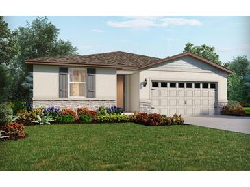 Charming single-story home featuring a two-car garage, lush landscaping, and elegant stone accents at 113 Archer Ave, Lake Alfred, FL 33850